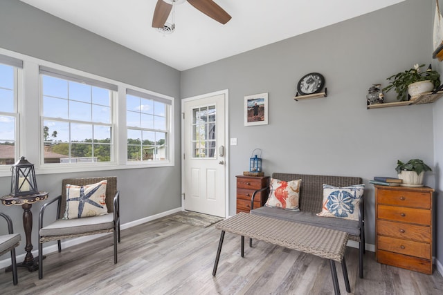 sitting room with ceiling fan and light wood-type flooring