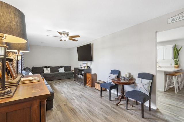 living room featuring ceiling fan and light hardwood / wood-style floors