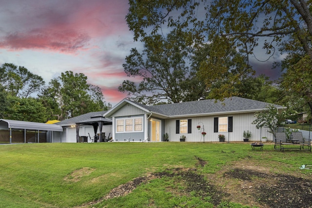 view of front of home with a carport, a garage, and a yard