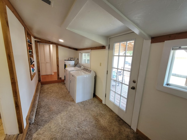 clothes washing area featuring separate washer and dryer, light carpet, a wealth of natural light, and laundry area