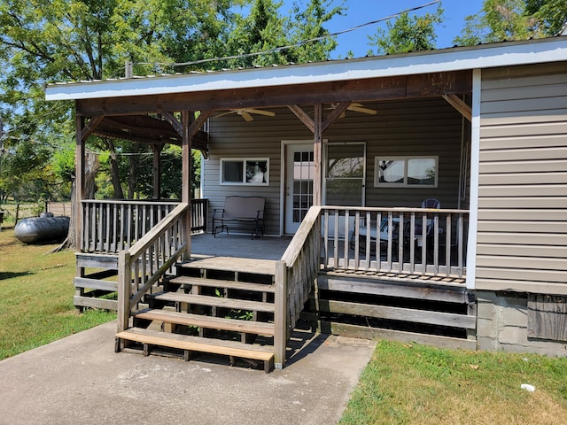 property entrance featuring a yard and ceiling fan