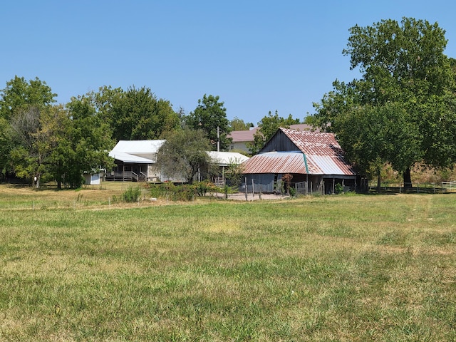 view of yard with a barn, a carport, and fence