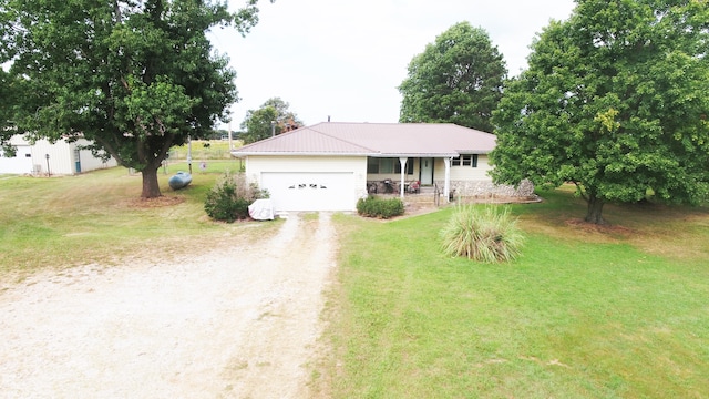 ranch-style house featuring covered porch, a garage, and a front lawn