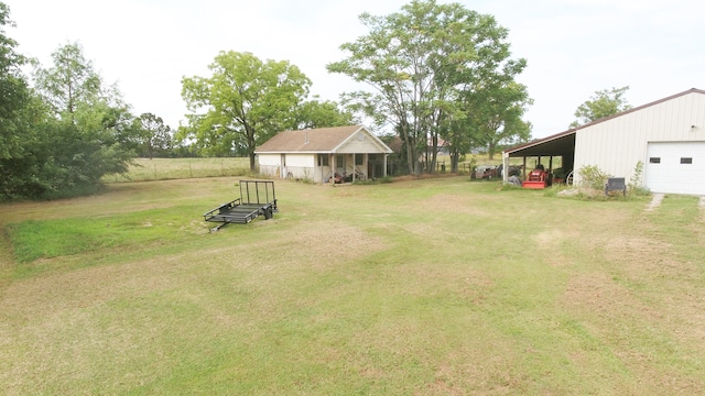 view of yard featuring a garage, an outdoor structure, and a carport