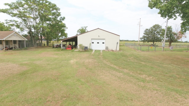 view of yard featuring a garage, an outbuilding, and a carport