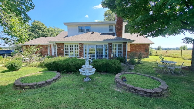 rear view of property with a lawn