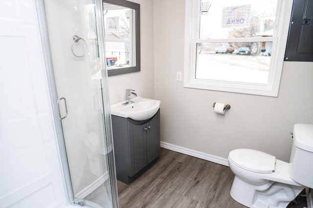 bathroom featuring a shower with door, hardwood / wood-style floors, vanity, and toilet