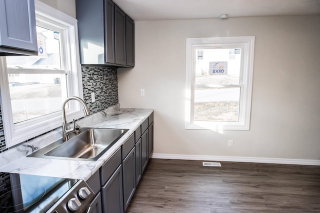 kitchen with gray cabinets, dark wood-type flooring, sink, and a healthy amount of sunlight