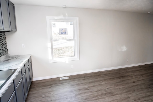 500 E Lincoln St, Buffalo, MO 65622 - kitchen featuring dark wood finished floors, gray cabinets, light stone countertops, baseboards, and tasteful backsplash