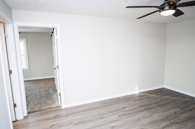 unfurnished room with light hardwood / wood-style floors, a textured ceiling, and ceiling fan