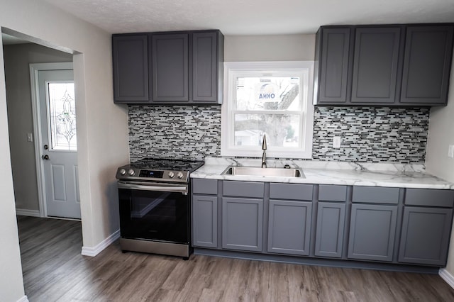 kitchen with stainless steel range, sink, dark hardwood / wood-style flooring, and gray cabinetry