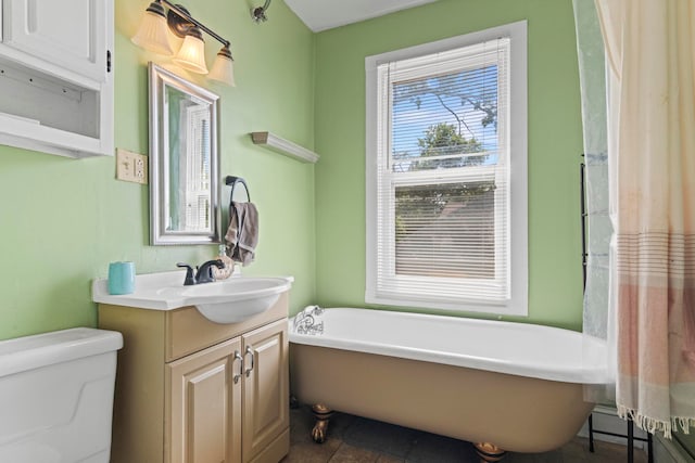 bathroom featuring a bathing tub, tile patterned floors, vanity, and toilet