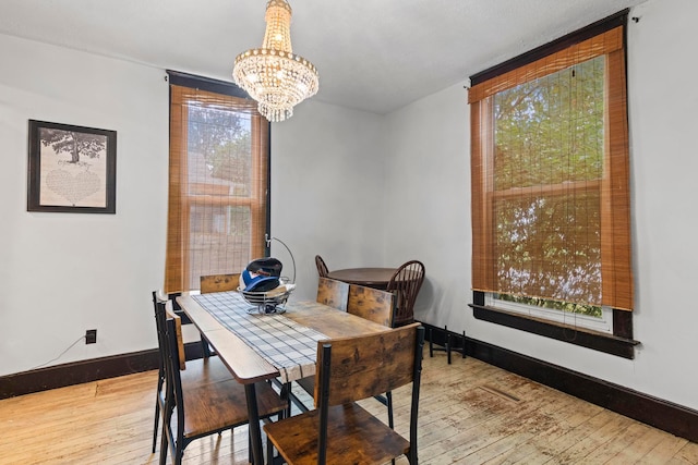 dining area with an inviting chandelier and light hardwood / wood-style floors