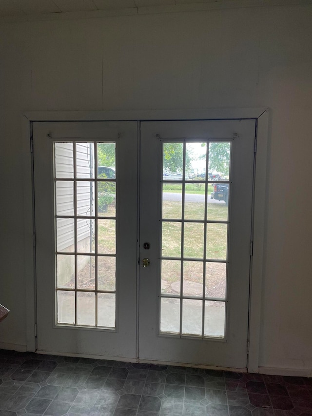 doorway featuring french doors and dark tile patterned flooring