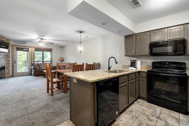 kitchen with pendant lighting, sink, kitchen peninsula, black appliances, and light carpet