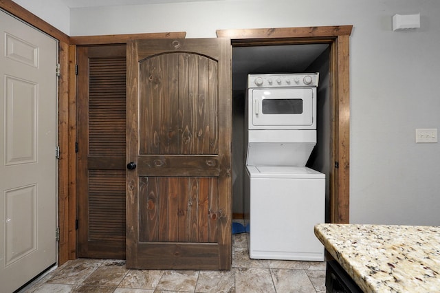 clothes washing area featuring stacked washer / dryer