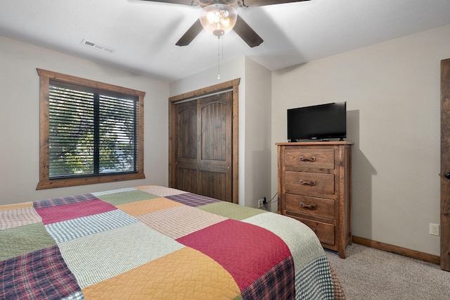 carpeted bedroom featuring ceiling fan and a closet