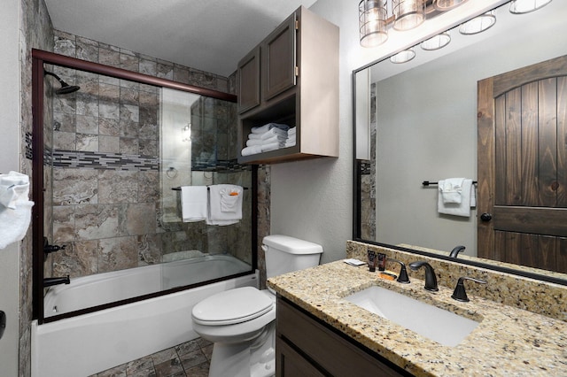 full bathroom with a textured ceiling, toilet, shower / bath combination with glass door, and vanity