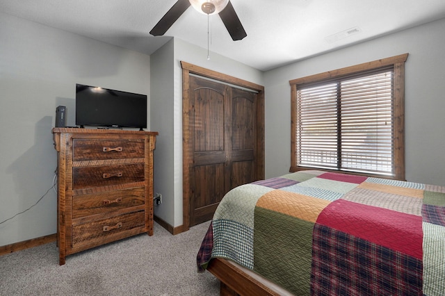 carpeted bedroom with ceiling fan and a closet