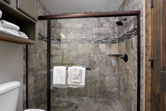 bathroom featuring walk in shower, a textured ceiling, and toilet