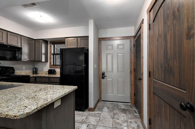 kitchen featuring a textured ceiling, dark brown cabinets, black appliances, and light stone countertops