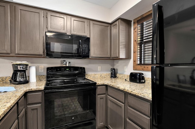 kitchen featuring black appliances and light stone countertops