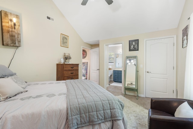 bedroom with lofted ceiling, light colored carpet, connected bathroom, and ceiling fan