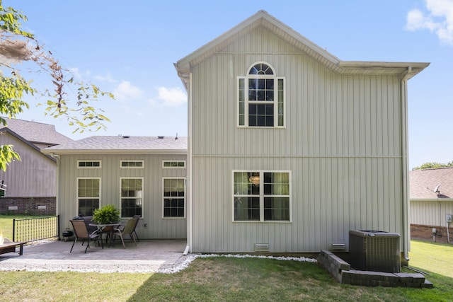 back of house featuring central AC, a patio, and a lawn