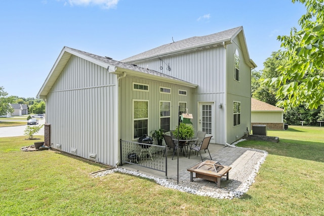 back of property with central air condition unit, a lawn, and a patio area