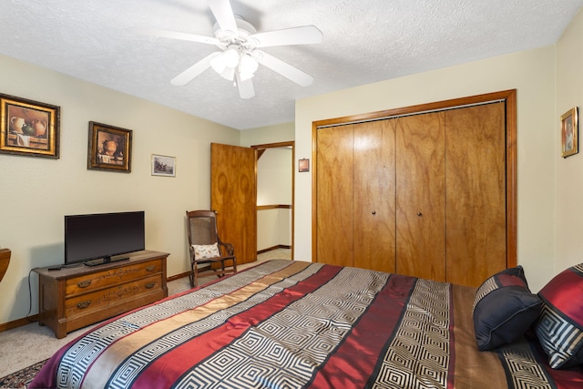 carpeted bedroom featuring ceiling fan, a closet, and a textured ceiling