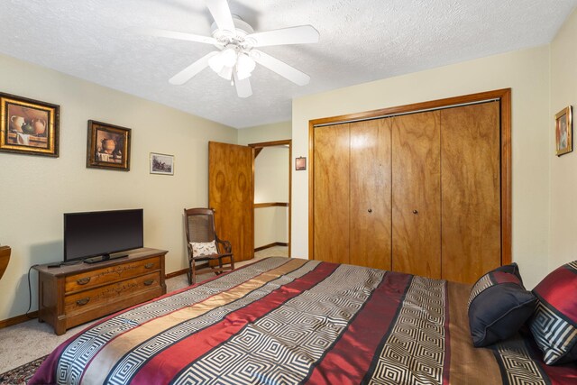 carpeted bedroom with a closet, ceiling fan, baseboards, and a textured ceiling