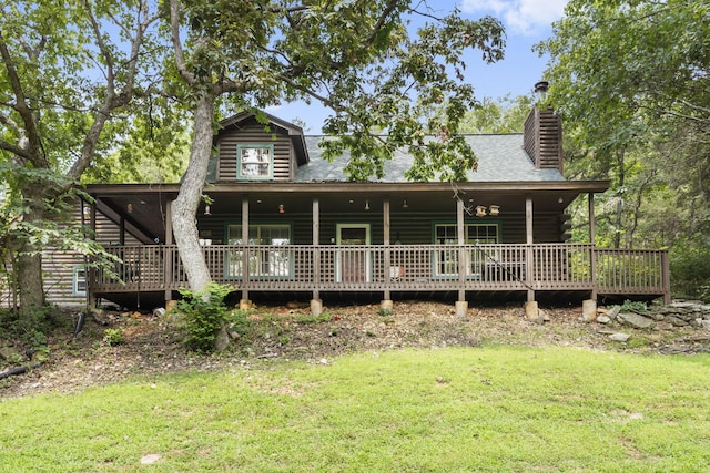 view of front of property featuring a front yard and a wooden deck