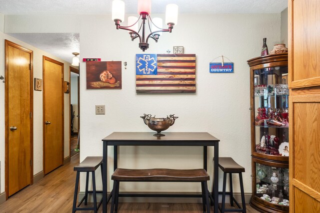 interior space with light wood-style flooring, a chandelier, and a textured ceiling