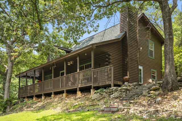 rear view of property with roof with shingles and a chimney