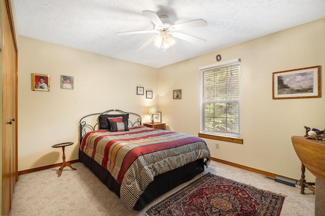 carpeted bedroom with ceiling fan and a textured ceiling