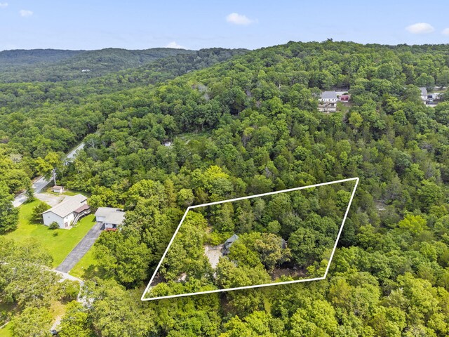 birds eye view of property featuring a view of trees