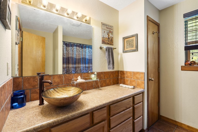 bathroom featuring vanity, tile patterned flooring, and a textured ceiling