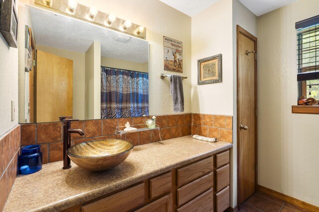 bathroom featuring tile patterned floors, tasteful backsplash, and vanity