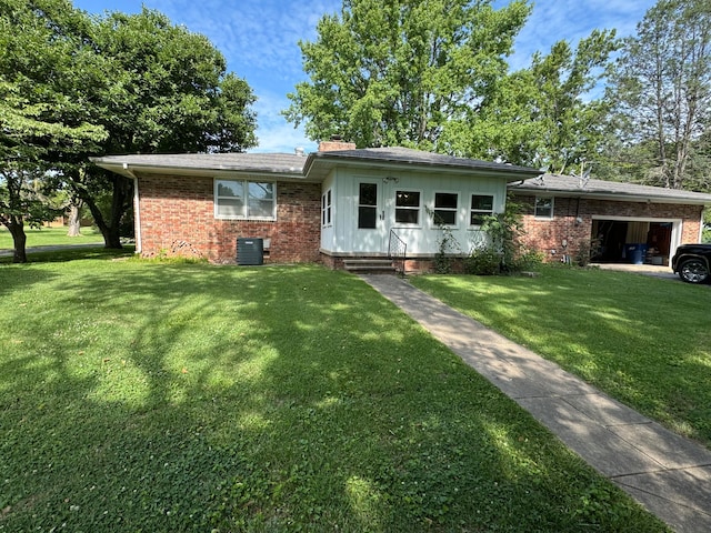 ranch-style home with a front yard, central AC, brick siding, and an attached garage