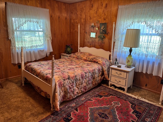 carpeted bedroom featuring wooden walls