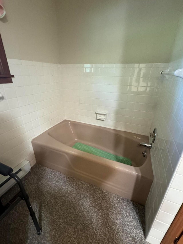 bathroom featuring a garden tub and tile walls