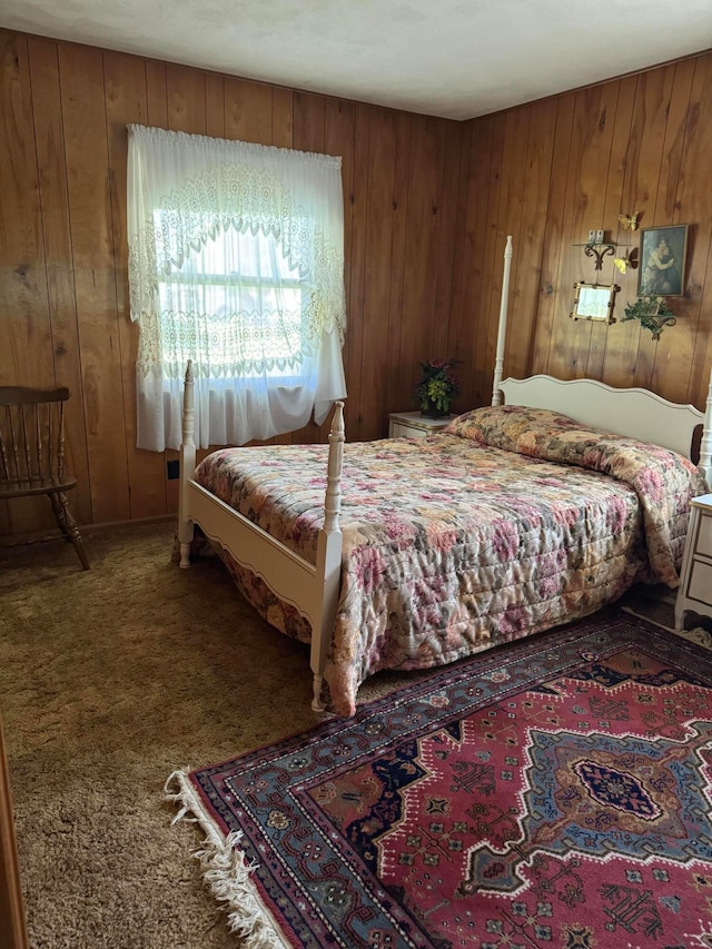 bedroom with carpet floors and wood walls