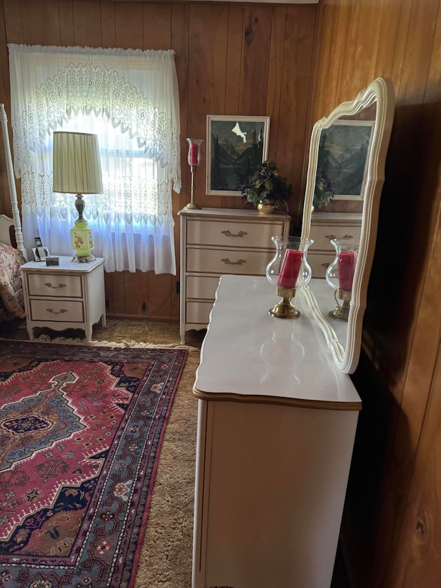 bedroom with wooden walls and carpet floors