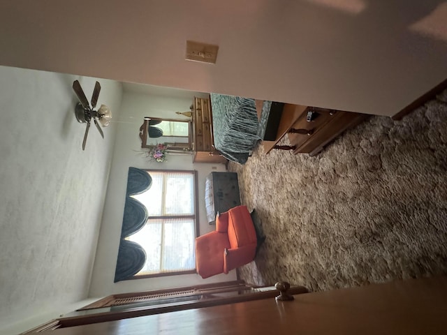 living room with ceiling fan, beamed ceiling, and hardwood / wood-style flooring