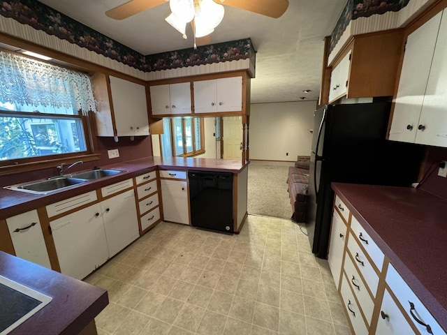 kitchen featuring plenty of natural light, black appliances, dark countertops, and a sink