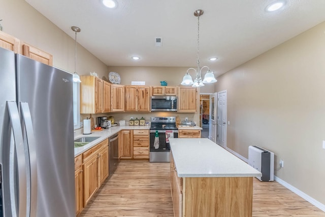 kitchen featuring a kitchen island, light hardwood / wood-style floors, hanging light fixtures, and stainless steel appliances