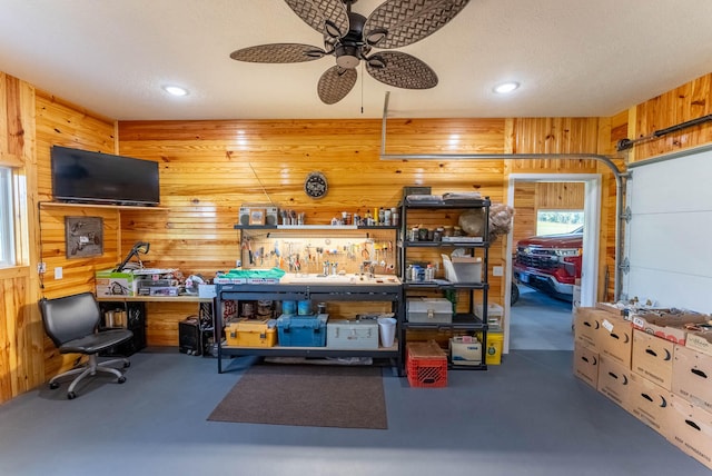 interior space featuring ceiling fan and wood walls