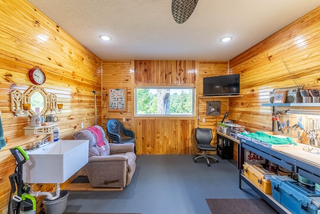 office area with wood walls and a textured ceiling