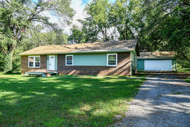 single story home with an outbuilding, a front yard, and a garage