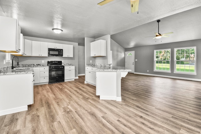 kitchen featuring light hardwood / wood-style flooring, white cabinets, black appliances, and sink